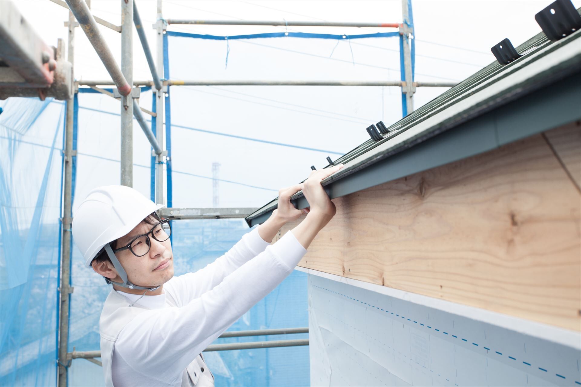 屋根の作業をする建築現場の男性スタッフ